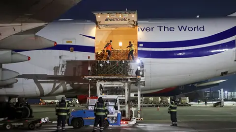 Workers unload the new batch of military aid from the US after arriving at Boryspil International Airport. Photo: -/Ukrinform/dpa.