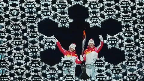 04 February 2022, China, Beijing: Chinese nordic combined skiier Zhao Jiawen (L) and Yilamujiang Dinigeer light the Olympic Cauldron during the opening ceremony of the Beijing 2022 Winter Olympics at the Bird's Nest National Stadium. Photo: Michael Kappeler/dpa.