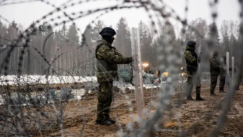 27 January 2022, Poland, Tolcze: Armed border guards are seen guarding the border line with Belarus during the construction works. Poland has started building wall on its eastern border intended to block migrants pushed by Belarus, in what the European Union calls a “hybrid attack,” from crossing illegally into EU territory. Photo: Attila Husejnow/SOPA Images via ZUMA Press Wire/dpa.