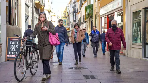 10 February 2022, Spain, Seville: A woman without a mask walks her bicycle along a street in Seville. The Spanish health authorities have lifted the mask requirement outdoors as case numbers fall. Photo: Eduardo Briones/EUROPA PRESS/dpa.
