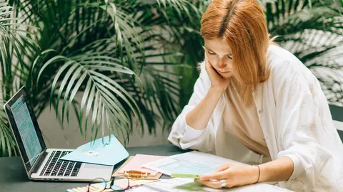 IRPF income tax woman red hair work laptop. Photo: Pexels.