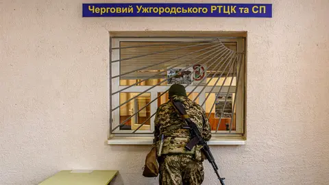 25 February 2022, Ukraine, Uzhhorod: An armed man in a camouflage uniform is pictured at the Zakarpattia Regional Territorial Centre for Staffing and Social Support, on the second day of the Russian invasion of Ukraine. Photo: -/Ukrinform/dpa.