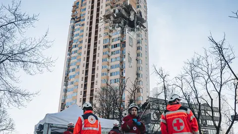 26 February 2022, Ukraine, Kiev: Emergency services stand in front of a multi-storey residential building in Kiev that was hit by a rocket on the third day of the Russian invasion of Ukraine. Photo: Diego Herrera/EUROPA PRESS/dpa