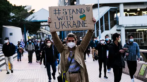 25 February 2022, China, Hong Kong: An Ukrainian woman holds a sign and walk on the street to protest against the Russian invasion of Ukraine. Photo: Keith Tsuji/ZUMA Press Wire/dpa.