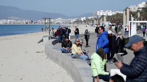 PRODUCTION - 26 February 2022, Spain, Palma: People crownd on the beach of Arenal in Mallorca. The Spanish island of Mallorca has scrapped nearly all coronavirus restrictions. Photo: Clara Margais/dpa.