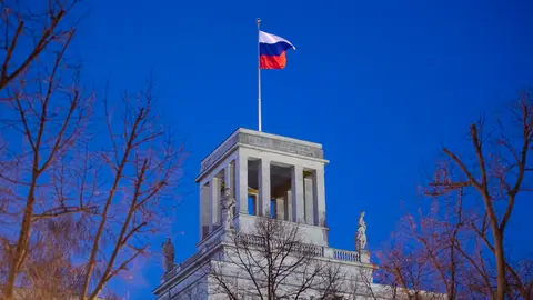 01 March 2022, Berlin: A flag of the Russian Federation flies over the Russian Embassy in Berlin. Photo: Christophe Gateau/dpa.