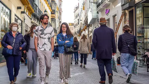 10 February 2022, Spain, Seville: A couple without masks and other pedestrians walk down a street in Seville. The Spanish health authorities have lifted the mask requirement outdoors as case numbers fall. Photo: Eduardo Briones/EUROPA PRESS/dpa.