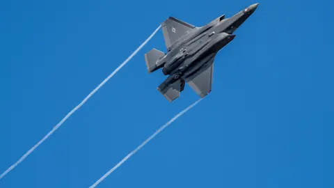23 February 2022, Rhineland-Palatinate, Spangdahlem: A US F-35 jet fighter flies over Germany's Eifel mountain range. The US Armed Forces have already transferred stealth fighter jets to Spangdahlem Air Base a few days ago. Photo: Harald Tittel/dpa.