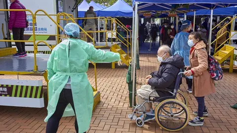 23 February 2022, China, Hong Kong: An elderly man in a wheel chair enters a mobile sample collection for Covid-19 testing in Hong Kong's Central district. Hong Kong is facing the 5th wave of Covid-19 and it's the worst since the start of the epidemic with more than 6,000 daily cases. Photo: Emmanuel Serna/SOPA Images via ZUMA Press Wire/dpa.