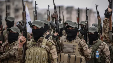 17 February 2022, Syria, Idlib city: Fighters from the Popular Resistance Brigades take part in a military parade in Idlib city during their graduation from a military course in the presence of the Prime Minister of the Syrian Salvation Government. Photo: Anas Alkharboutli/dpa.