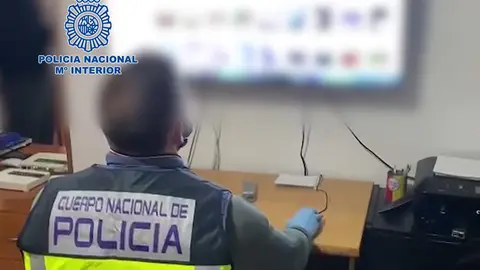 A police officer reviews part of the material seized in one of the homes  searched. Image: Police.