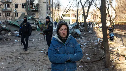 18 March 2022, Ukraine, Kiev: A woman walks past an apartment building damaged by Russian shelling in the Podil neighborhood. Photo: Mykhaylo Palinchak/SOPA Images via ZUMA Press Wire/dpa.