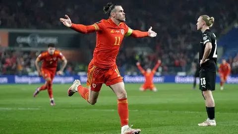 24 March 2022, United Kingdom, Cardiff: Wales' Gareth Bale (L) celebrates scoring his side's second goal during the FIFA World Cup Qualifiers semi final soccer match between Wales and Austria at Cardiff City Stadium. Photo: Nick Potts/PA Wire/dpa.