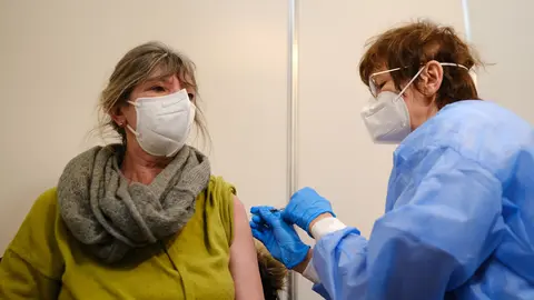 01 March 2022, Bremen: Martina Zongos (L) receives a dose of Novavax vaccine against COVID-19 in a vaccination booth at a vaccination center. Photo: Markus Hibbeler/dpa.