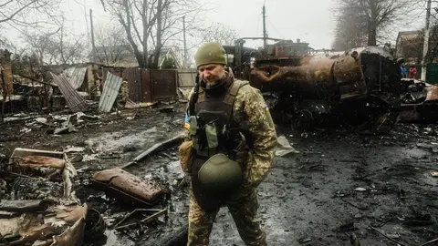 03 April 2022, Ukraine, Bucha: Ukrainian soldiers inspect the rubble of a destroyed Russian tank column on a road in Butcha, a suburb north of the capital. As Russian troops withdraw from areas north of the Ukrainian capital, Ukrainian officials are calling the heavy civilian casualties found in the town of Bucha a deliberate war crime, drawing international condemnation. Photo: Matthew Hatcher/SOPA Images via ZUMA Press Wire/dpa.