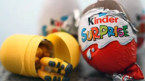 04 April 2022, United Kingdom, London: A toy lies next to a British variant of a Kinder Surprise egg. Due to more than 60 cases of salmonella illnesses in the UK, Ferrero has recalled some batches of children's surprise eggs just under two weeks before Easter. Photo: Victoria Jones/PA Wire/dpa.
