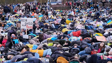 06 April 2022, Berlin: Demonstrators lie on the lawn in front of the Reichstag building during a demonstration against the attack on Ukraine and for an energy embargo against Russia. Photo: Annette Riedl/dpa.