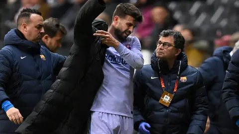 07 April 2022, Hessen, Frankfurt/M.: Barcelona's Gerard Pique puts on a jacket after leaving the pitch with an injury during the UEFA Europa League quarterfinal first leg soccer match between Eintracht Frankfurt and FC Barcelona at Deutsche Bank Park. Photo: Arne Dedert/dpa.