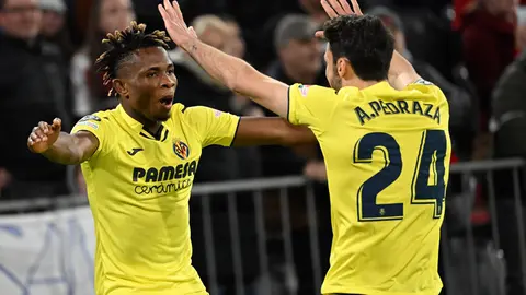 12 April 2022, Bavaria, Munich: Villareal's Samuel Chimerenka Chukwueze (L) celebrates scoring his side's first goal with team mate Alfonso Pedraza Sag during the UEFA Champions League Quarter-final second leg soccer match between FC Bayern Munich and Villarreal CF at Allianz Arena. Photo: Angelika Warmuth/dpa.