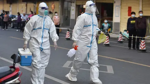 10 April 2022, China, Fuyang: Medical personnel in protective suits walk on a street, in a cordoned-off area in Fuyang. Mainland China reported 1,318 new confirmed local corona cases on Saturday 09 April, up from 1,334 on Friday, the National Health Commission said. Photo: Sheldon Cooper/SOPA Images via ZUMA Press Wire/dpa.