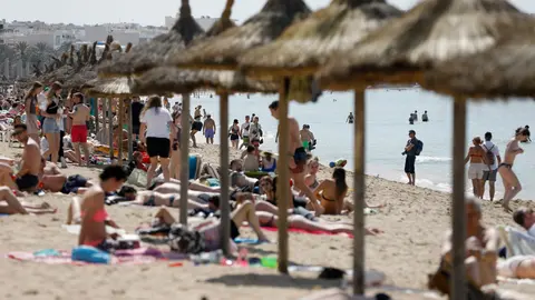 16 April 2022, Spain, Palma: Tourists chill on the beach of Arenal during the Easter week. Photo: Clara Margais/dpa.
