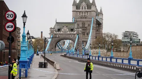 08 April 2022, United Kingdom, London: Police officers block access to Tower Bridge, east London, as activists from Extinction Rebellion hang from suspension cords beside a giant banner that reads "End fossil fuels now", as they stage a protest which has closed the bridge to traffic. Photo: Victoria Jones/PA Wire/dpa.
