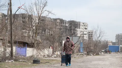 29 March 2022, Ukraine, Mariupol: A woman makes her way out of Mariupol on foot after heavy bombardment left much of the city in ruins. The battel between Russian/Pro Russian forces and the defencing Ukrainian forces lead by Azov battalion continues in the port city of Mariupol. Photo: Maximilian Clarke/SOPA Images via ZUMA Press Wire/dpa.