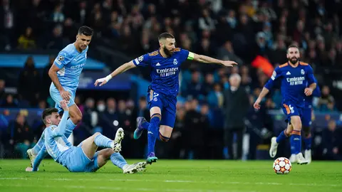 26 April 2022, United Kingdom, Manchester: Manchester City's Ruben Dias tackles Real Madrid's Karim Benzema during the UEFA Champions League Semi Final, First Leg, soccer match between Manchester City and Real Madrid at the Etihad Stadium. Photo: Mike Egerton/PA Wire/dpa.