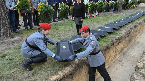 05 May 2022, Brandenburg, Halbe: Boxes containing the remains of 86 German soldiers are buried at Germany's largest war grave-site nearly 77 years after the end of WWII during a memorial service organized by the German War Graves Commission at the Waldfriedhof. Photo: Patrick Pleul/dpa.