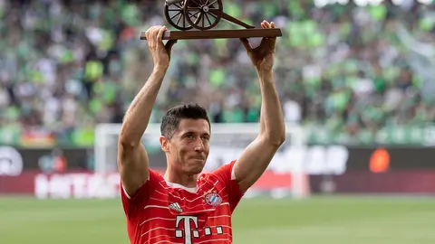 FILED - 14 May 2022, Lower Saxony, Wolfsburg: Bayern Munich's Robert Lewandowski holds up the Kicker scoring canon as top scorer after the German Bundesliga soccer match between VfL Wolfsburg and Bayern Munich at Volkswagen Arena. arcelona have made a first written transfer bid of 32 million euros (33.8 million dollars) for Bayern Munich striker Robert Lewandowski, according to a report on Sunday. Photo: Swen Pförtner/dpa.