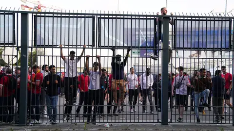 28 May 2022, France, Paris: People try to climb gates outside the ground as the kick off is delayed during the UEFA Champions League final soccer match between Liverpool FC and Real Madrid CF at the Stade de France. Photo: Adam Davy/PA Wire/dpa.