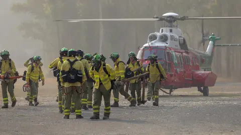 09 June 2022, Spain, Pujerra: Firefighters who worked all night on the wildfire in the Sierra Bermeja mountain range arrive by helicopter at the command post in Pujerra. Photo: Álex Zea/EUROPA PRESS/dpa.