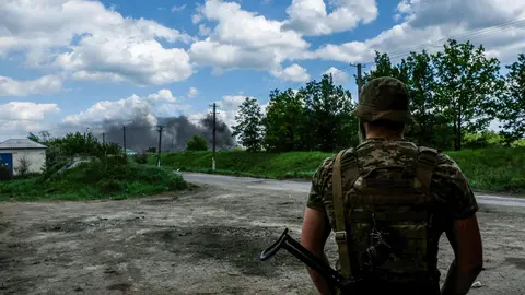 27 May 2022, Ukraine, Lysychans'k: A soldier looks at the smoke coming from the oil refinery of Lysychans'k. Lysychans'k is an elongated city on the high right bank of the Donets River in the Luhansk region. The town is now the frontline since the Russian destroyed the bridge connecting Severodonetsk to Lysychans'k, Russian troops are attacking the city and moving towards it. Photo: Rick Mave/SOPA Images via ZUMA Press Wire/dpa.