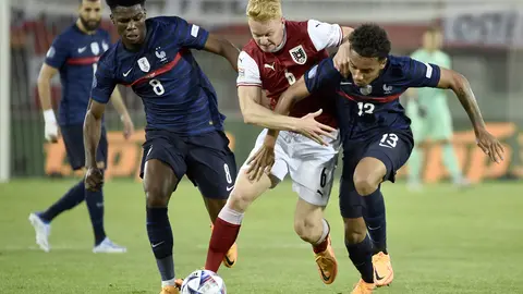 10 June 2022, Austria, Vienna: France's Aurelien Tchouameni (L) and Boubacar Kamara battle for the ball with Austria's Nicolas Seiwald battle for the ball during the UEFA Nations League Group A soccer match between Austria and France at Ernst Happel Stadium. Photo: Hans Punz/APA/dpa.