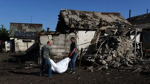 21 June 2022, Ukraine, Kharkiv: People carry the body of Raisa Kozakova, 85 years old, after she was killed when a shell hit her home while she was picking peas. Photo: Carol Guzy/ZUMA Press Wire/dpa.