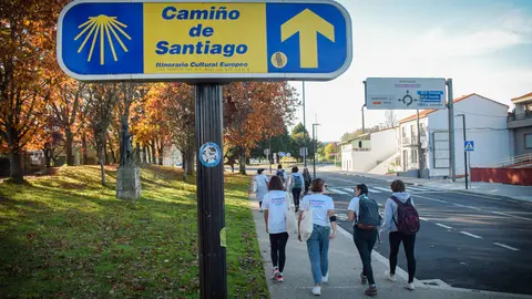 A group of young visitors to Santiago de Compostela passing by a sign indicating the Saint James Way. Photo: Pablo Morilla.