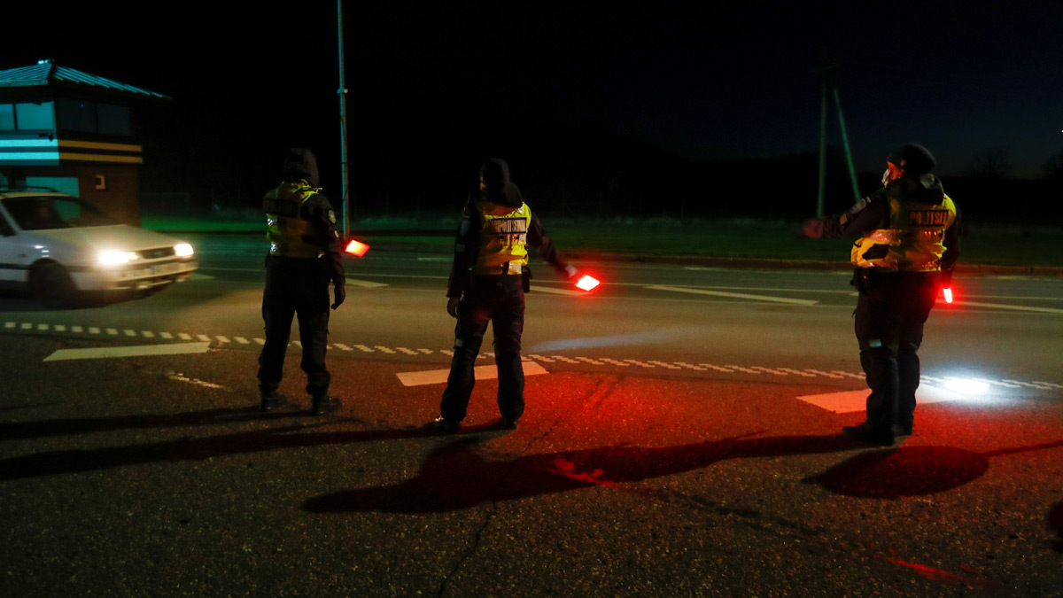 Estonian police and border guard officers show the car driver where to go at border crossing point between Estonia and Latvia, as travel restrictions for residents of Latvia, Lithuania and Estonia are lifted during the coronavirus disease (COVID-19) outbreak in Ikla, Estonia May 15, 2020. REUTERS/Ints Kalnins