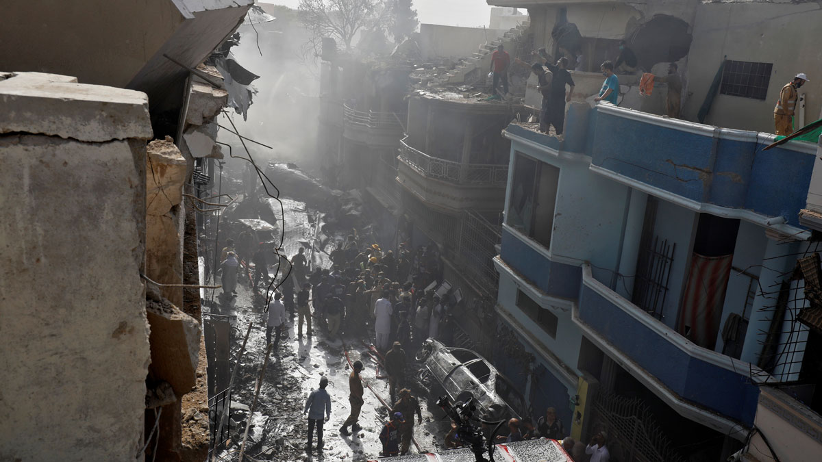 Rescue workers gather at the site of a passenger plane crash in a residential area near an airport in Karachi, Pakistan May 22, 2020. REUTERS/Akhtar Soomro