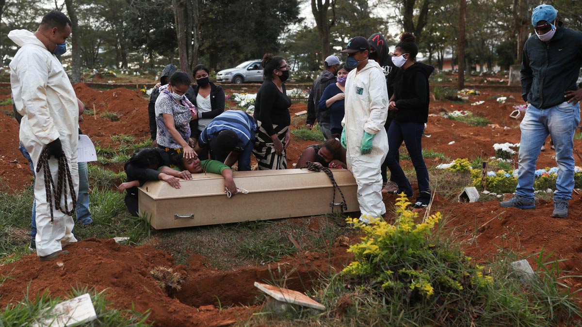Relatives react during the burial of 64-year-old Raimunda Conceicao Souza, who died from the coronavirus disease (COVID-19), at Vila Formosa cemetery, Brazil's biggest cemetery, in Sao Paulo, Brazil, May 22, 2020. REUTERS/Amanda Perobelli