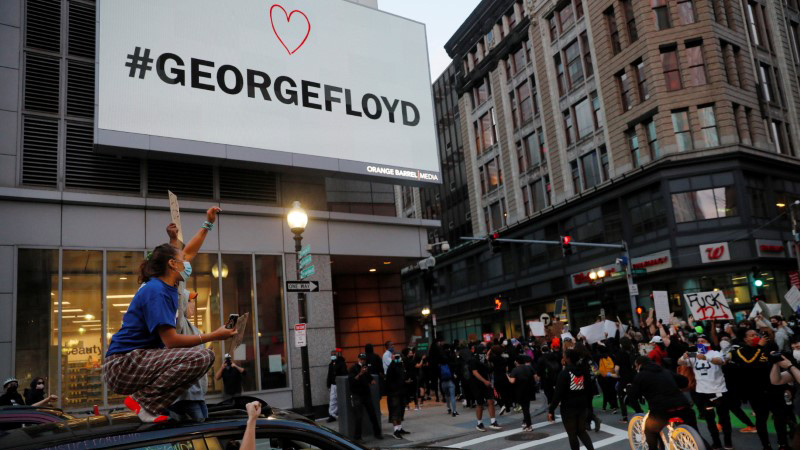 Passengers in car cheer as protestors rally against the death in Minneapolis police custody of George Floyd, beneath a billboard with his name on it, in Boston, Massachusetts, U.S., May 31, 2020. Picture taken May 31, 2020. REUTERS/Brian Snyder