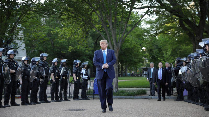 FILE PHOTO: U.S. President Donald Trump walks between lines of riot police in Lafayette Park across from the White House after walking to St John's Church for a photo opportunity during ongoing protests over racial inequality in the wake of the death of George Floyd while in Minneapolis police custody, at the White House in Washington, U.S., June 1, 2020. REUTERS/Tom Brenner
