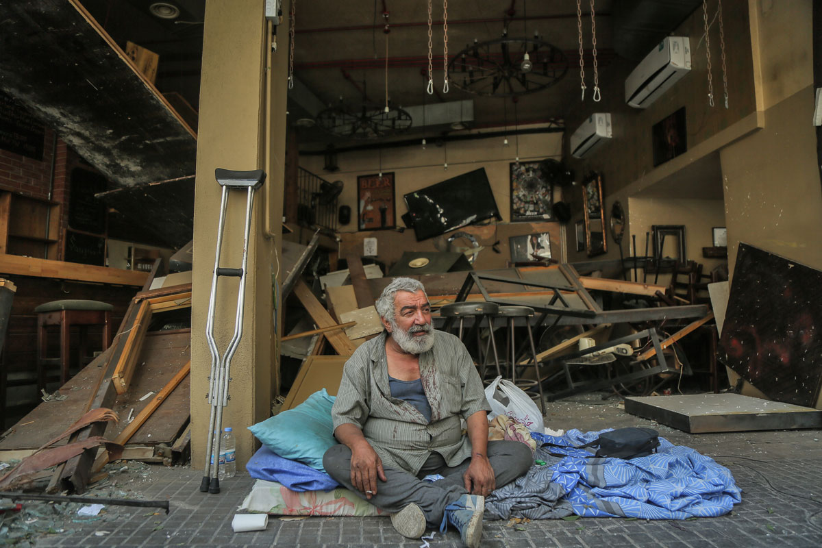 05 August 2020, Lebanon, Beirut: A man sits on the pavement in front of a destroyed bar a day after a massive explosion in Beirut's port that rocked the whole city, killing at least 100 people and injured thousands. Photo: Marwan Naamani/dpa.