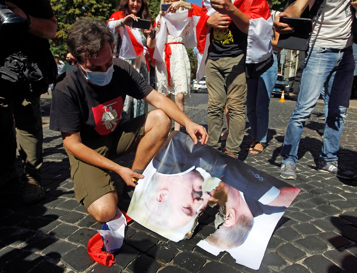 30 August 2020, Ukraine, Kiev: A protester burns a picture of Russian President Vladimir Putin and Belarus President Alexander Lukashenko during a protest outside the embassy of Belarus, in support of the Belarusian opposition. Photo: Pavlo Gonchar/dpa.