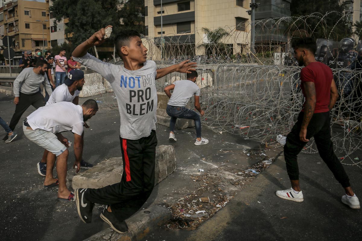 30 October 2020, Lebanon, Beirut: Protesters hurl stones at riot police during a demonstration against French President Emmanuel Macron's comments on Islam's prophet Muhammad cartoons, held outside the residence of the French ambassador in Beirut. Photo: Marwan Naamani/dpa