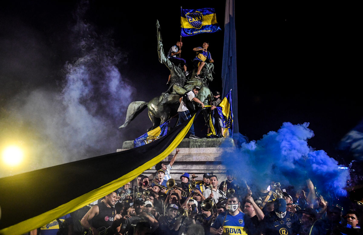 26 November 2020, Argentina, Buenos Aires: Fans wave flags of the club Boca Juniors as people take to the streets to bid farewell to late Argentinian football legend Diego Maradona. Argentina football great Diego Maradona has died at the age of 60, the Argentinian Football Association said on Wednesday. Photo: Fernando Gens/dpa.