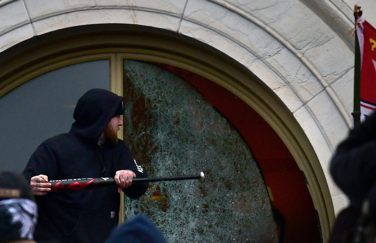 06 January 2021, US, Washington: A supporter of US President Donald Trump breaks a window of the US Capitol building during a protest against lawmakers meeting to certify president-elect Joe Biden's win in the November election. Photo: Carol Guzy/ZUMA Wire/dpa