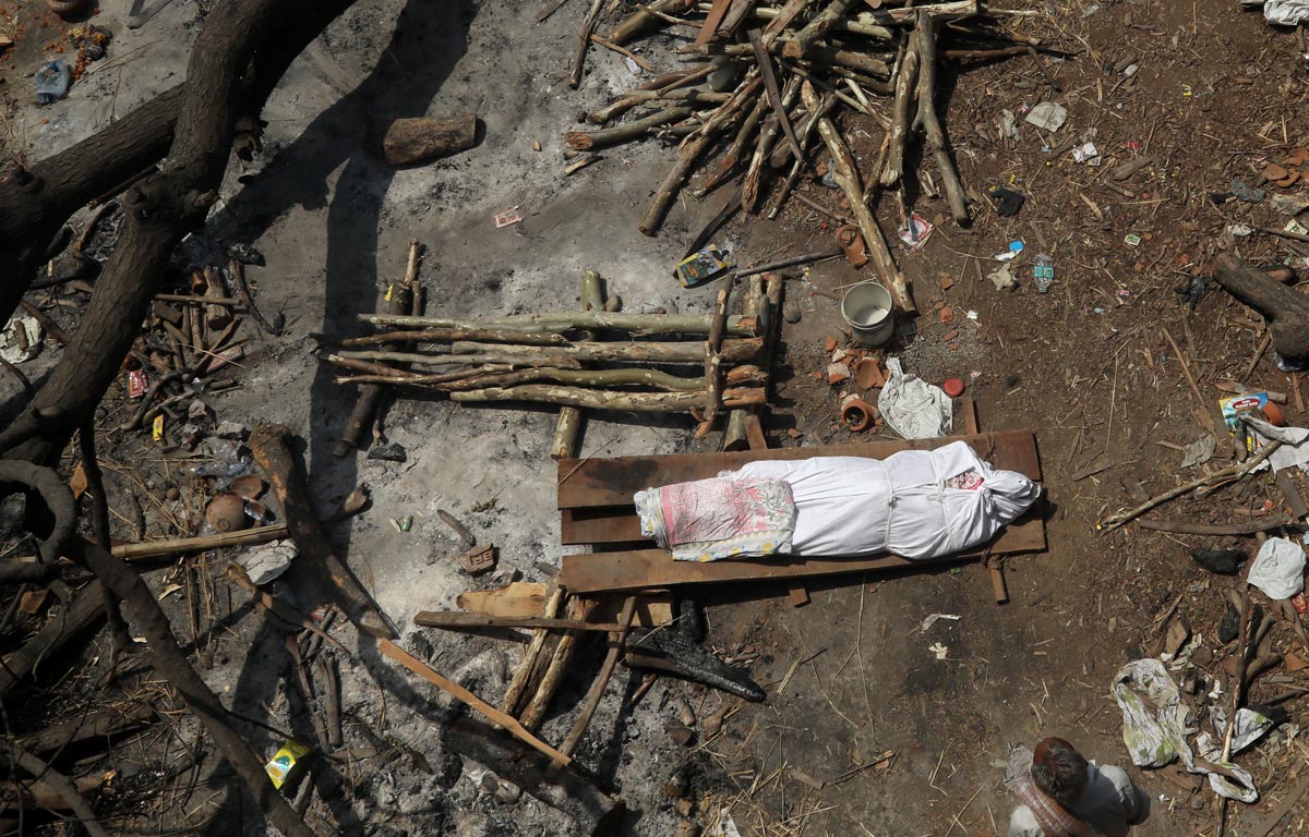 GRAPHICS - 26 April 2021, India, New Delhi: The body of a person who died from the of COVID-19 coronavirus lies before cremation at Ghazipur cremation ground in New Delhi. India saw a new global record of 352,991 daily new Covid-19 infections and 2,812 Covid-19 deaths on Monday as a second wave of the pandemic overwhelmed health systems. Photo: Naveen Sharma/SOPA Images via ZUMA Wire/dpa - ATTENTION: graphic content