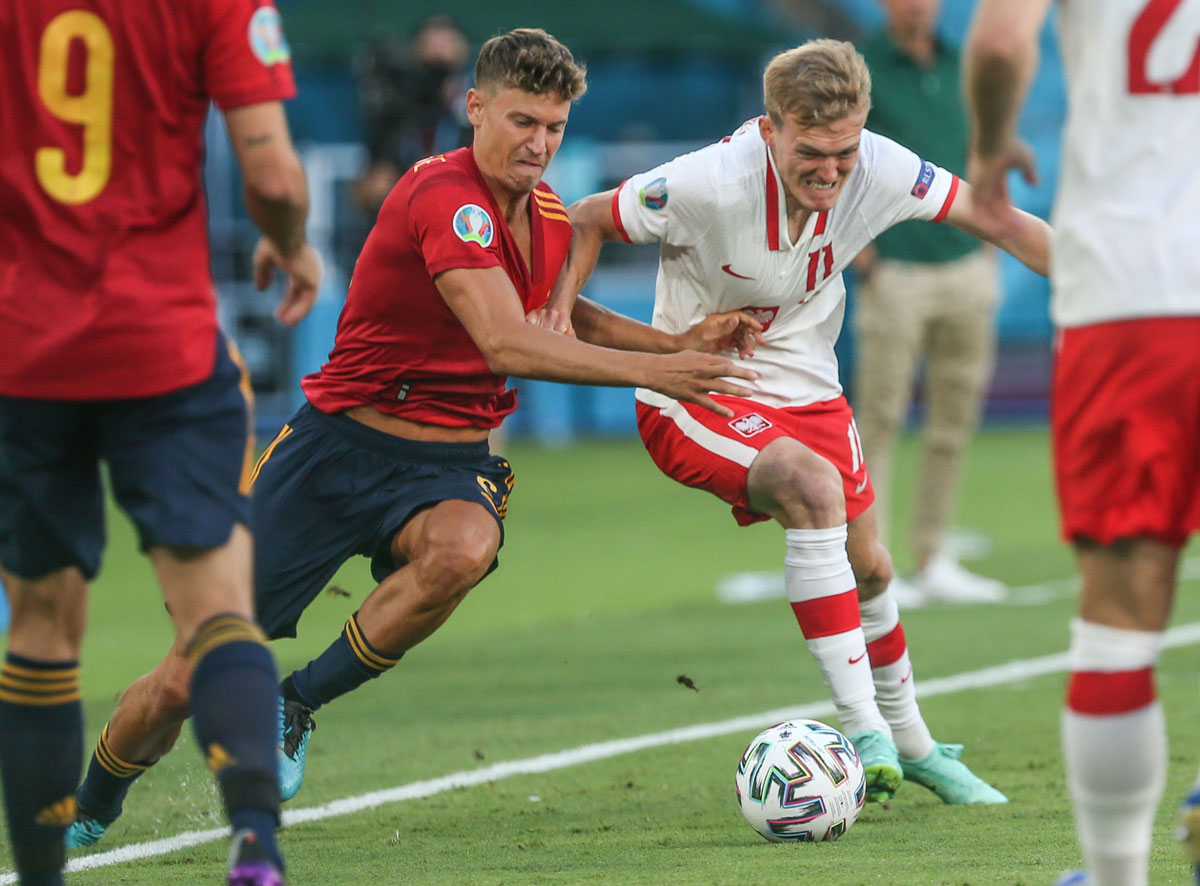 19 June 2021, Spain, Seville: Spain's Marcos Llorente (L) and Poland's Karol Swiderski battle for the ball during the UEFA EURO 2020 Group E soccer match between Spain and Poland at La Cartuja Stadium. Photo: Cezaro De Luca/dpa.