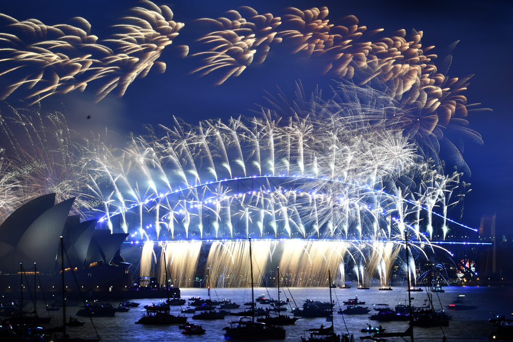 01 January 2022, Australia, Sydney: The midnight fireworks go off over the Sydney Opera House and Sydney Harbour Bridge during the New Year’s celebrations. Photo: Dean Lewins/AAP/dpa.