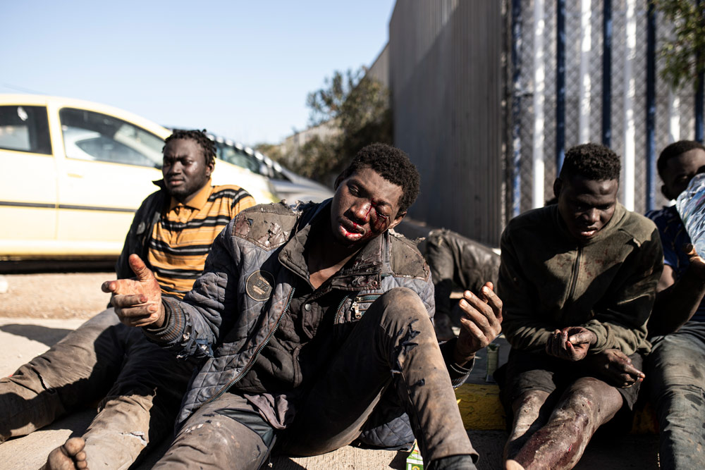 02 March 2022, Spain, Melilla: A migrant is seen injured after managing to jump the border fence of Melilla. According to Guardia Civil sources, up to 2,000 people of sub-Saharan origin have attempted to cross the Melilla border fence, of which 500 have succeeded and made their way to the Temporary Immigrant Stay Center (CETI). Photo: Ilies Amar/EUROPA PRESS/dpa.